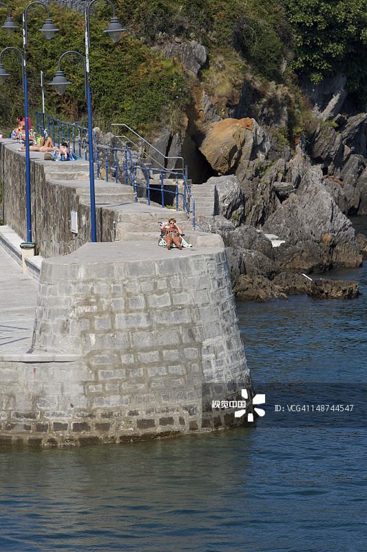 防波堤上的日光浴者图片素材