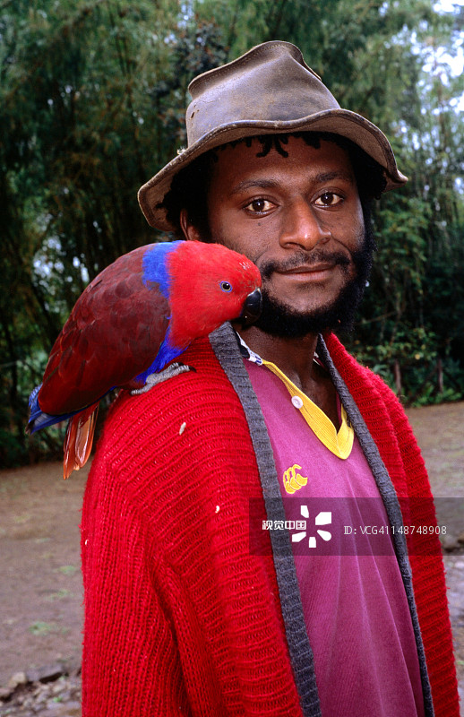 肩扛鹦鹉的戴帽子男人肖像图片素材