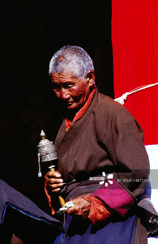 在色拉寺手持转经轮和念珠的老年妇女图片素材