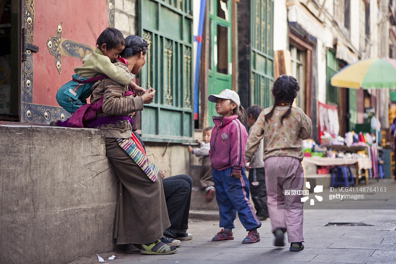 八廓街小巷里有几个孩子的街头家庭图片素材