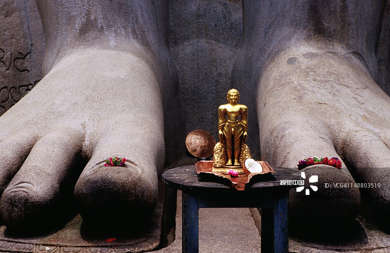 耆那教神祇戈马特斯瓦拉雕像脚下的微型复制品图片素材