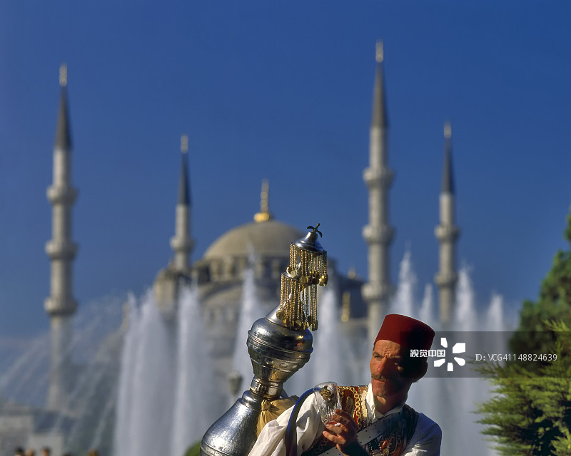 蓝色清真寺旁传统送水人图片素材