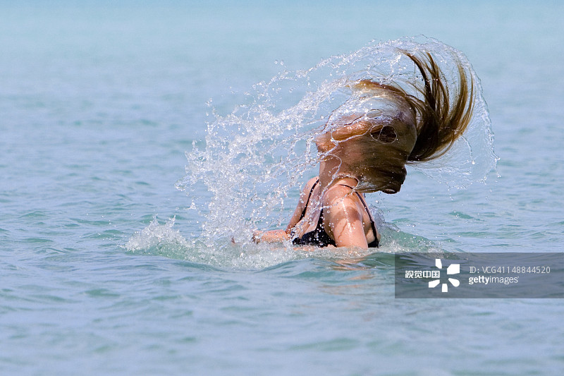在穆里泻湖沐浴时甩动湿发的女人图片素材