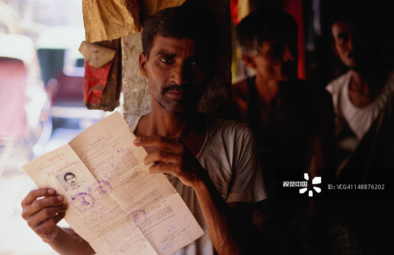 来自加尔各答的人力车夫穆罕默德·哈立德展示他的“出租马车驾驶执照”图片素材