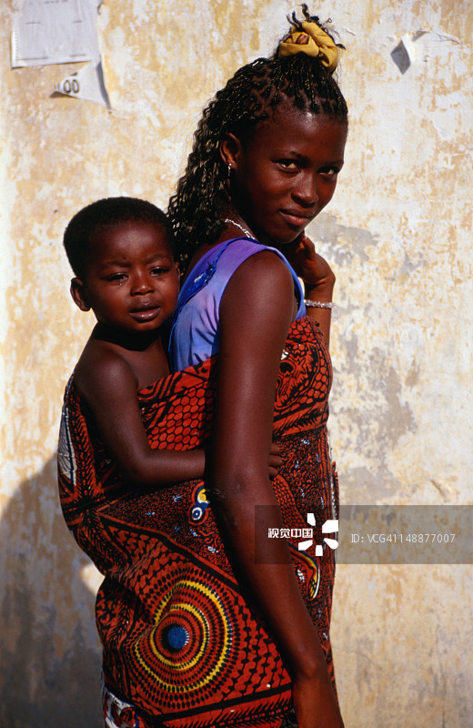 年轻母亲背着她的男婴图片素材