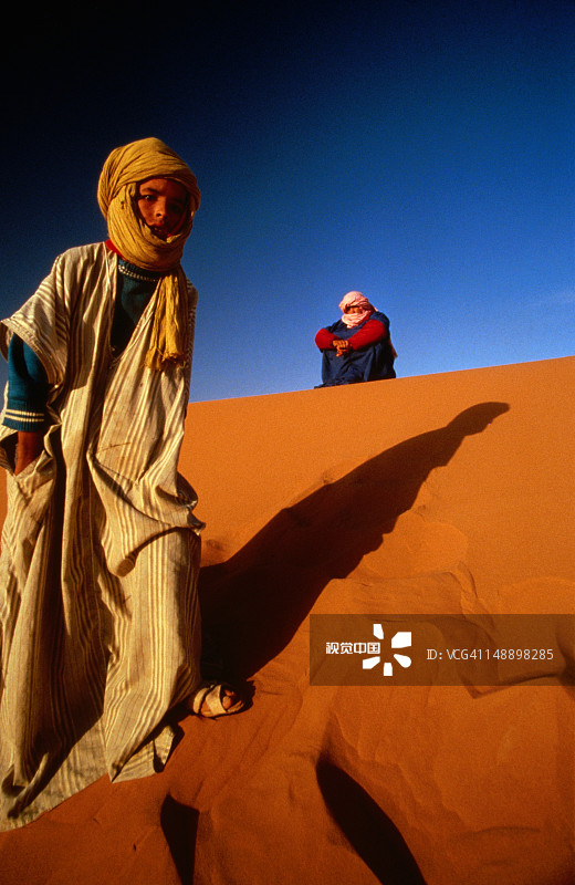 在梅尔祖卡沙漠沙丘上的年轻人图片素材