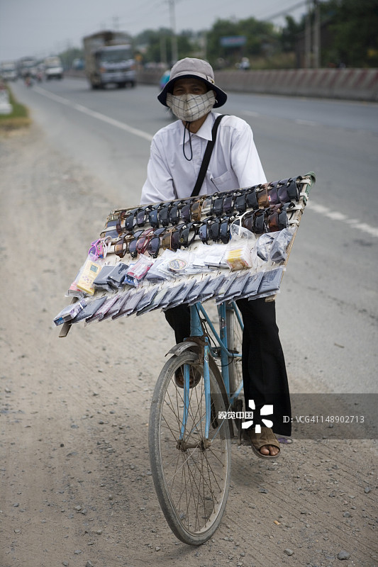 戴着太阳镜的自行车街头小贩图片素材