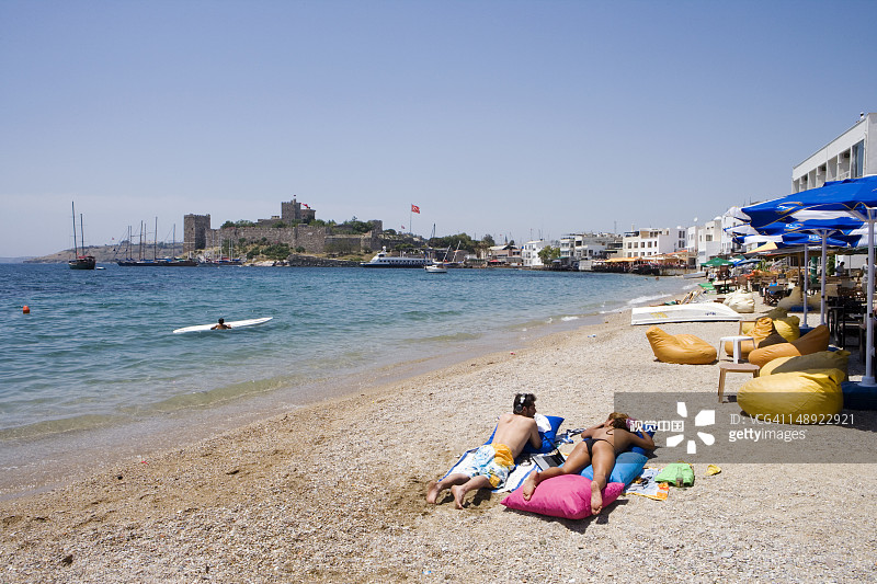 在海滩上，背景是圣彼得城堡的情侣图片素材