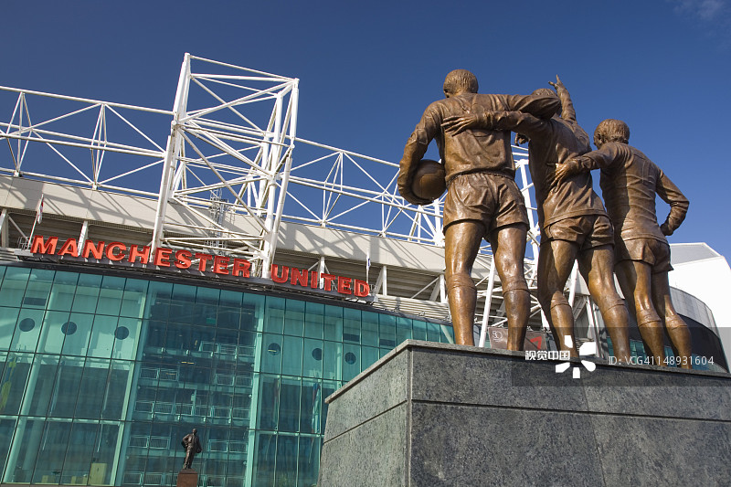 曼联足球场东立面，乔治·贝斯特、丹尼斯·劳和博比·查尔顿的雕像，老特拉福德图片素材