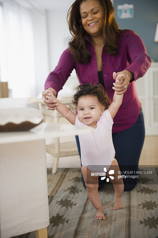 混血女人帮助婴儿学走路图片素材