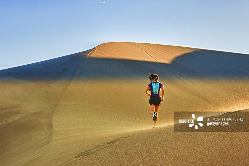 在沙丘上奔跑的西班牙裔妇女图片素材