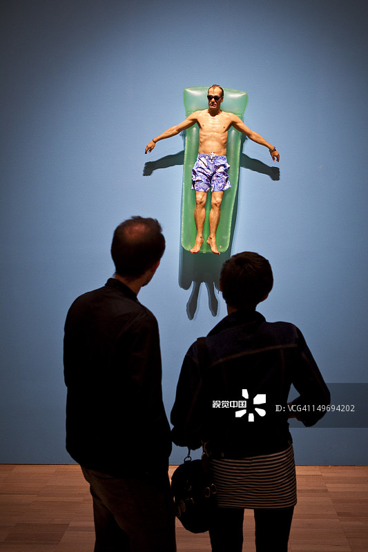 游客在维多利亚国家美术馆欣赏罗恩·穆克（Ron Mueck）的雕塑作品图片素材