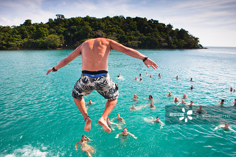 一群人在岛屿海岸附近游泳图片素材