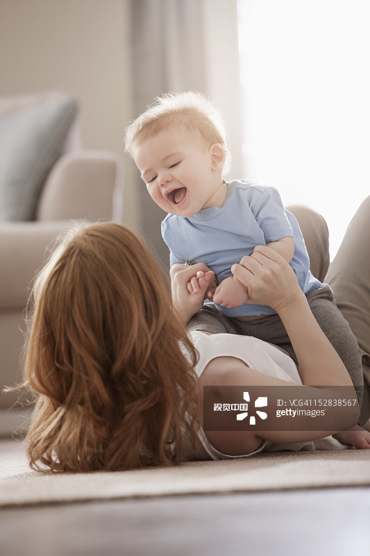 白人母亲在地板上和儿子玩耍图片素材