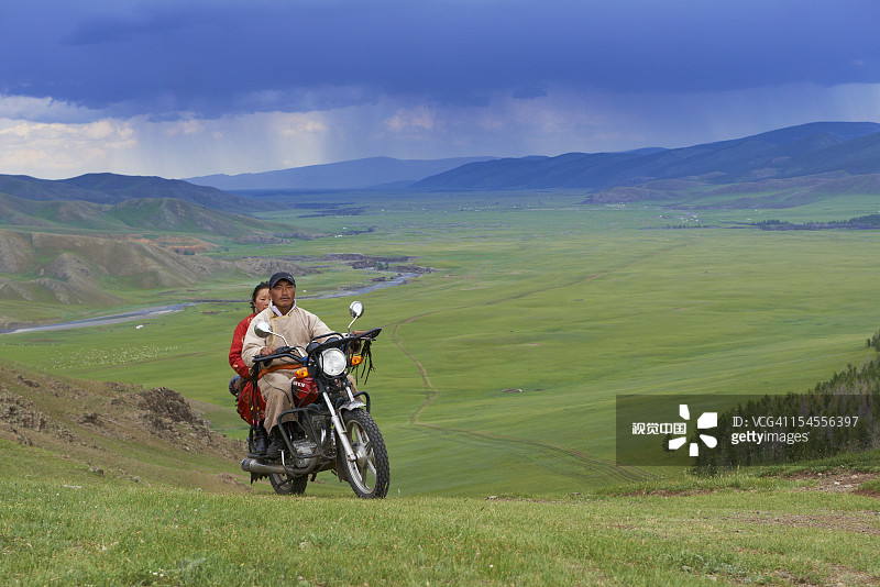 蒙古后杭盖省骑摩托车的牧民图片素材