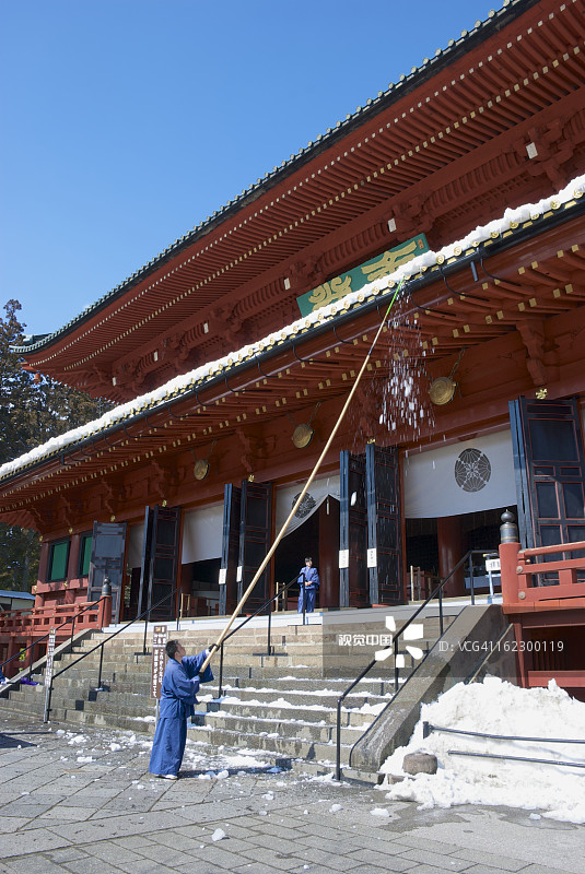 僧侣清扫轮王寺屋顶上的积雪图片素材