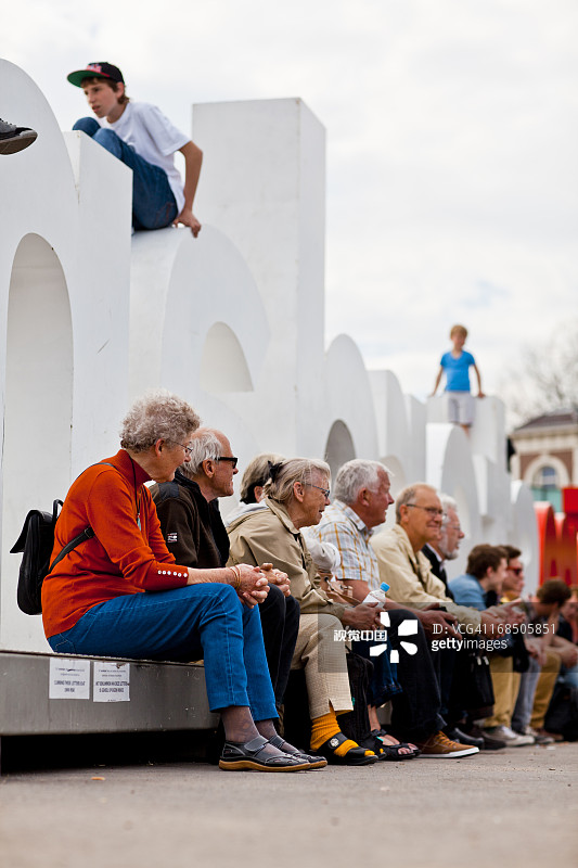 老年人坐在阿姆斯特丹标志旁图片素材