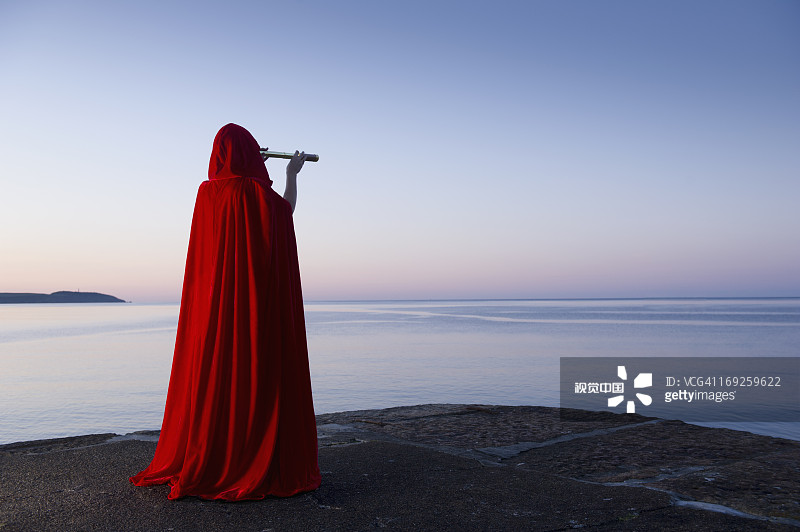 用望远镜俯瞰大海的白人女人图片素材