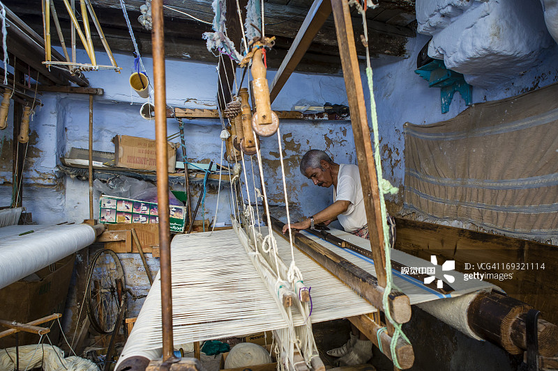 麦地那工坊里在织布机上工作的织布工图片素材