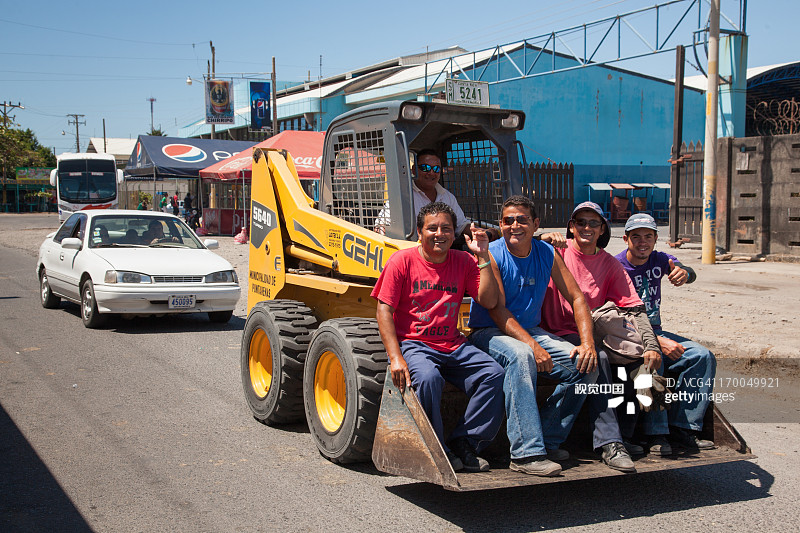 建筑工人乘坐推土机铲斗图片素材