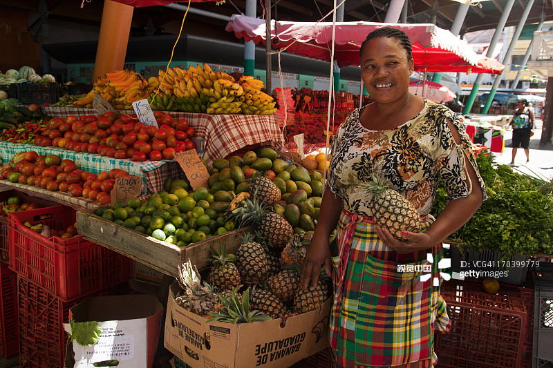 在市场上卖水果和蔬菜的女人图片素材