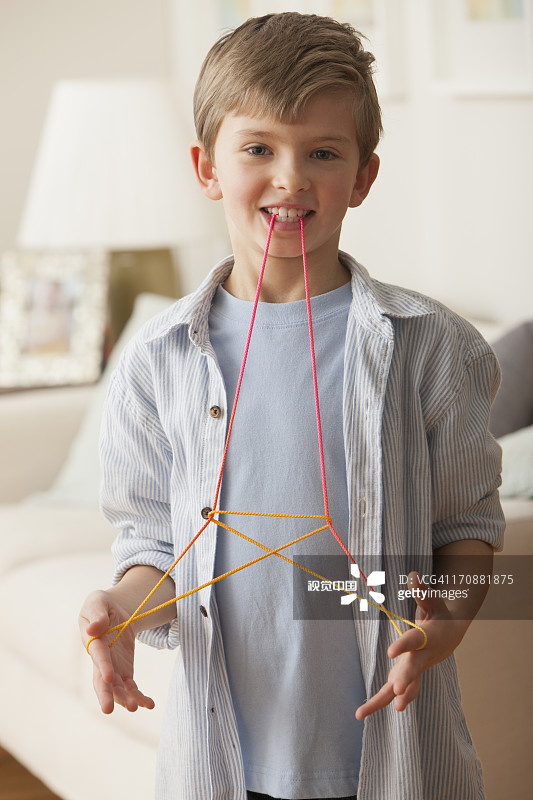 玩翻绳游戏的白人男孩图片素材