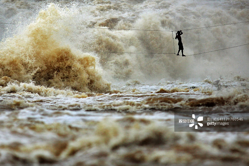 男子在高空钢丝上横渡湄公河图片素材