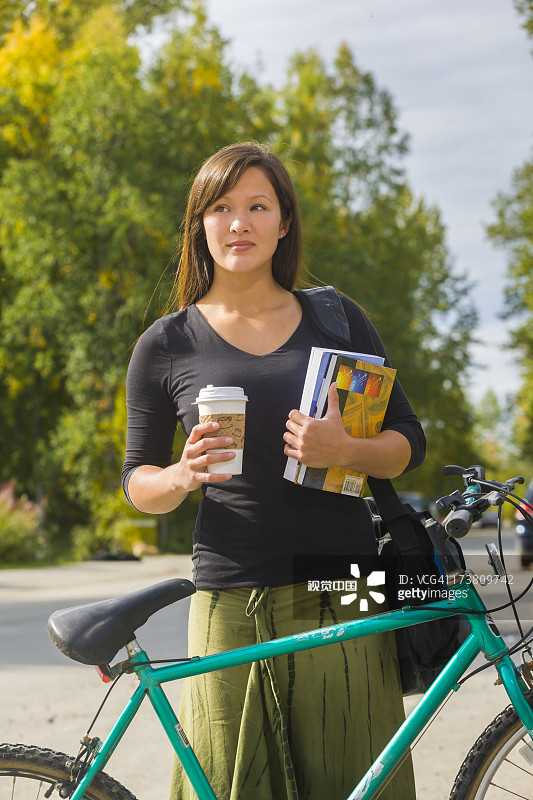 一个拿着咖啡和课本的阿拉斯加女人图片素材
