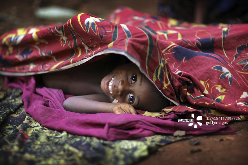 微笑的孩子躲在布单下图片素材