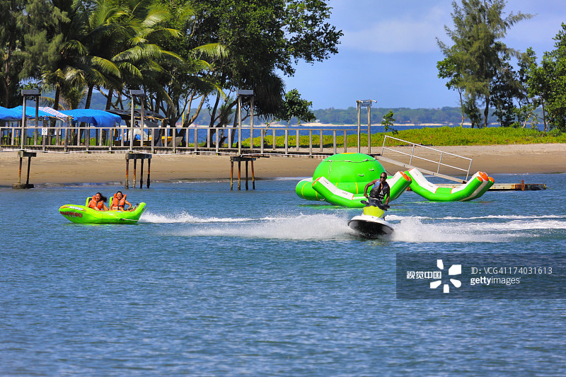 水上摩托拖拽载有游客的橡皮筏图片素材