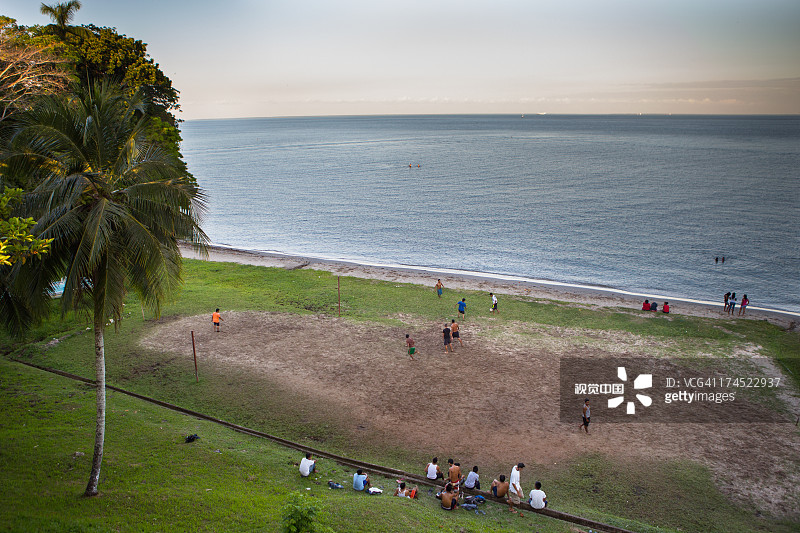海边踢足球的当地人图片素材