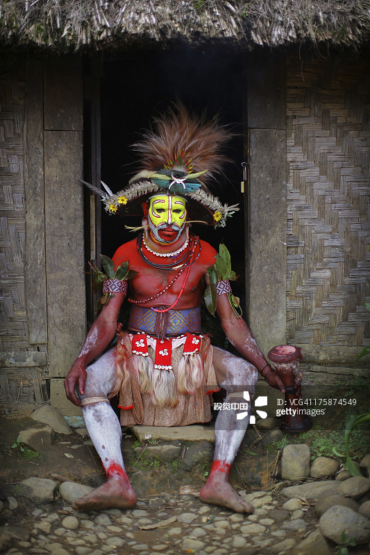 坐在茅草小屋外的胡利族假发男人图片素材