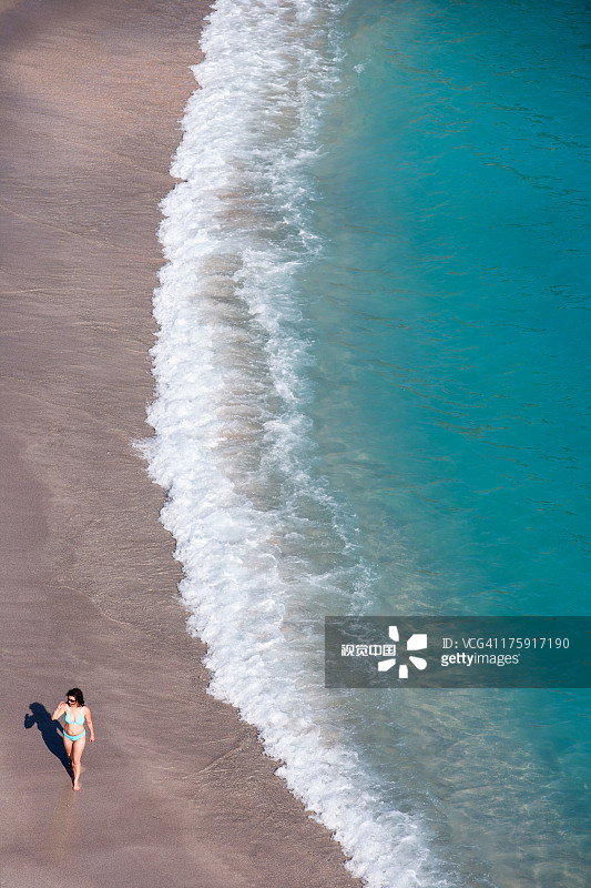 女人在贝壳海滩漫步图片素材