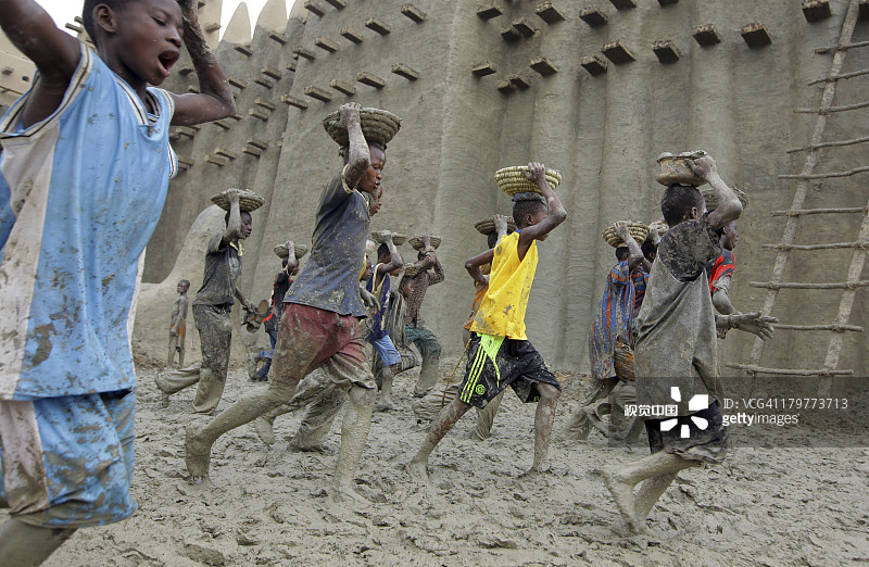 男孩们向马里杰内大清真寺运泥图片素材