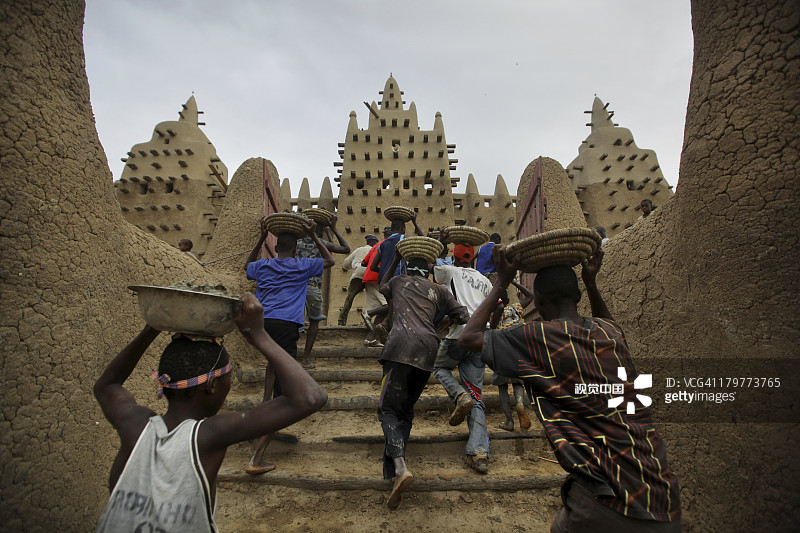 男人跑上杰内大清真寺的台阶图片素材