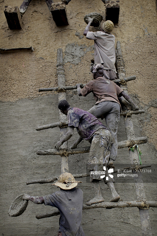 男人重塑马里杰内大清真寺的泥墙图片素材