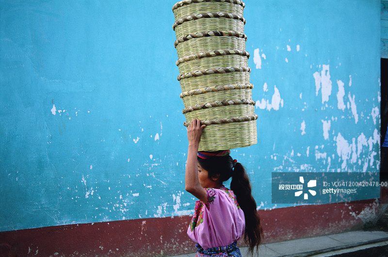 危地马拉阿蒂特兰湖，妇女头顶篮子的侧视图图片素材