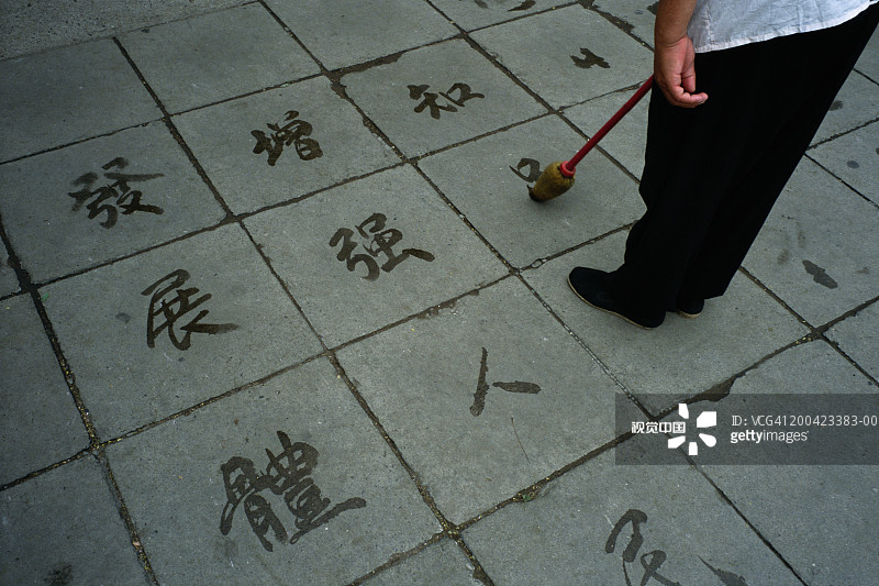 中国北京北海公园：男子在地上写字图片素材
