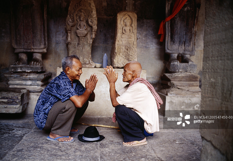 在吴哥寺内祈祷的两个男人图片素材