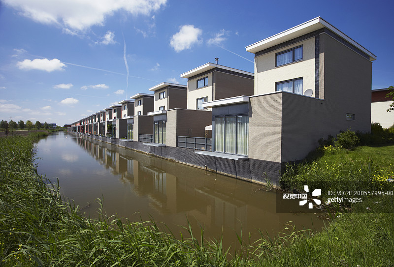 荷兰阿尔梅勒的运河、芦苇与现代建筑图片素材