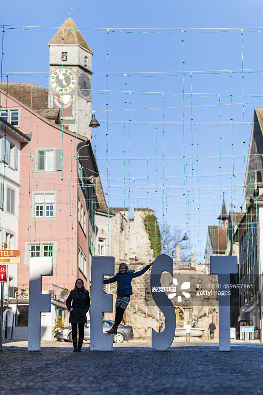 女孩在城镇节日标志前摆姿势图片素材