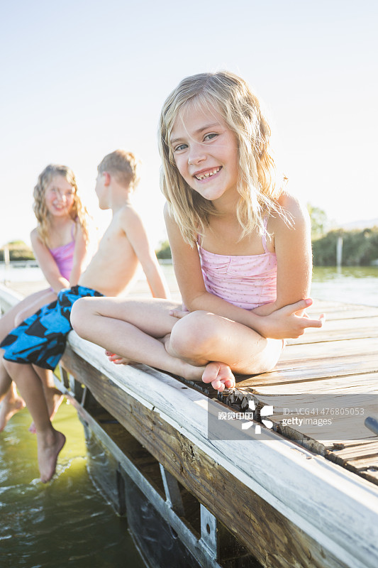 一个白人女孩坐在码头上图片素材