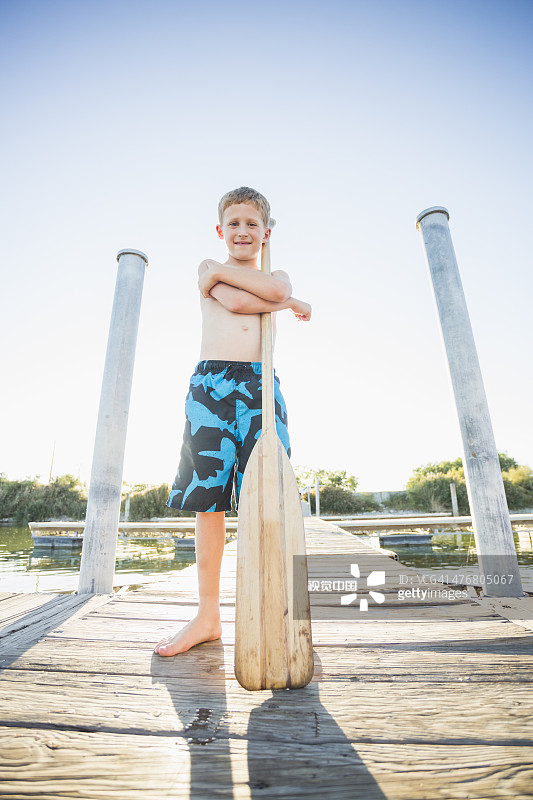 在码头上拿着桨的白人男孩图片素材