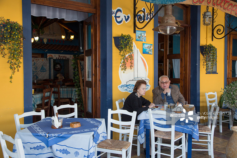情侣坐在小酒馆的户外餐桌旁图片素材