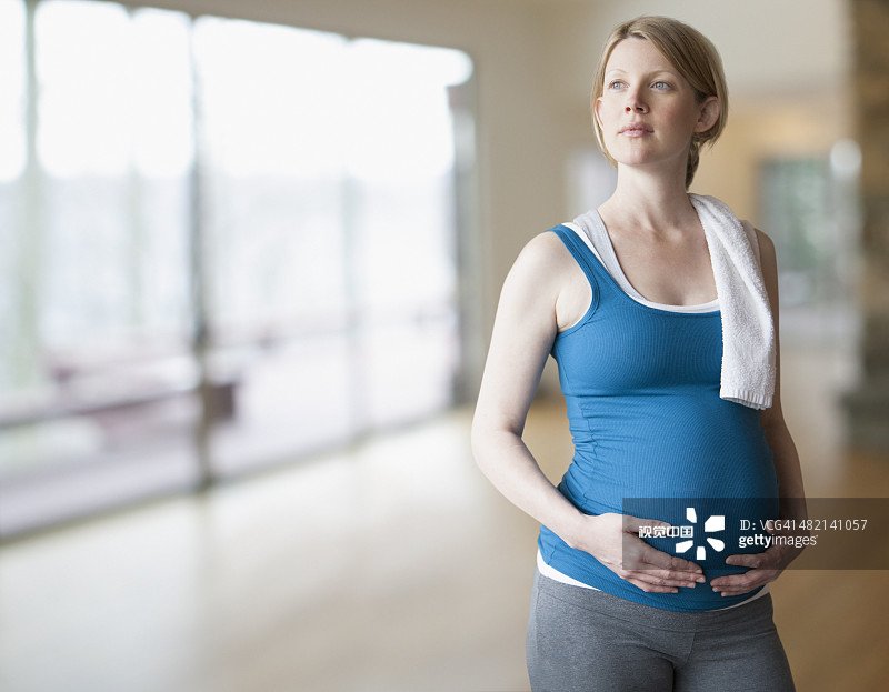 站在瑜伽馆里的怀孕白人妇女图片素材