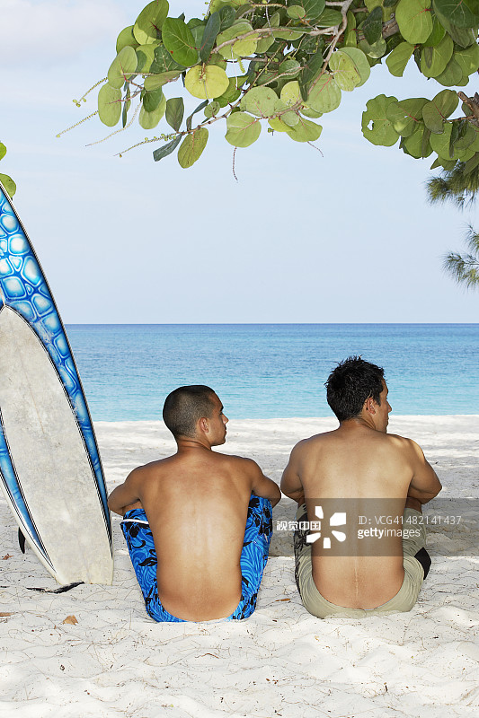 一起坐在海滩上的冲浪者图片素材