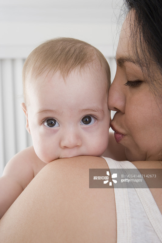 母亲亲吻西班牙裔男婴的脸颊图片素材