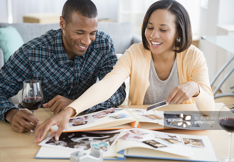 情侣喝红酒并看照片图片素材