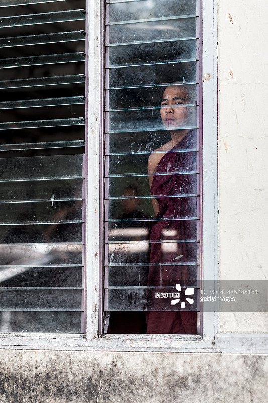 僧侣从窗户观察庭院图片素材
