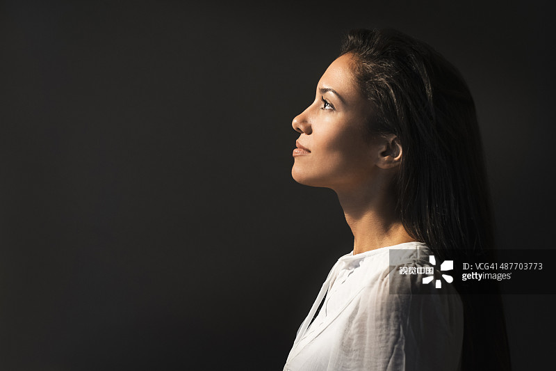 抬头看光的西班牙裔女子图片素材